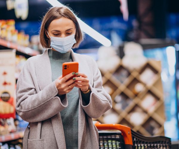 Woman wearing face mask and shopping in grocery store